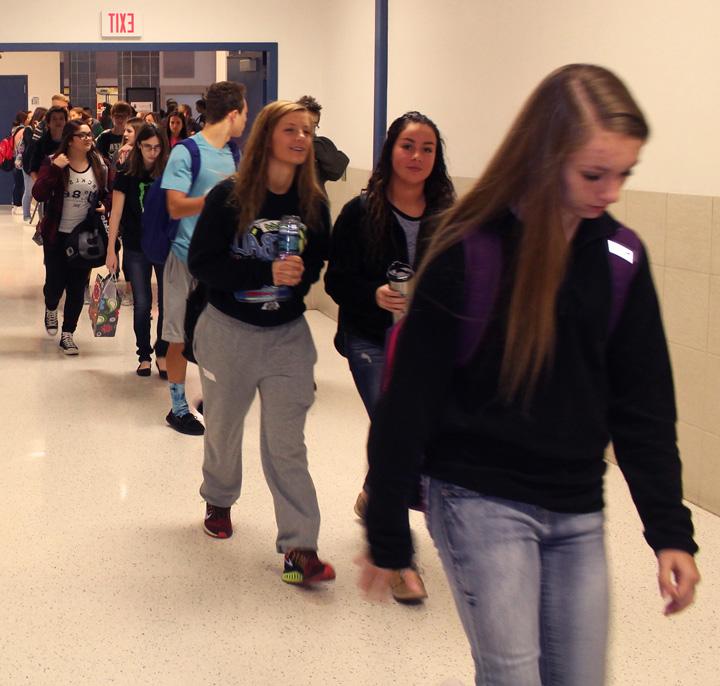 Students are walking in the hall during passing period.