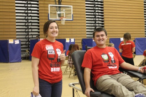 Senior Kelly Fitspatrick helping Senior Kort Steele being a team player at the NPHS blood drive.