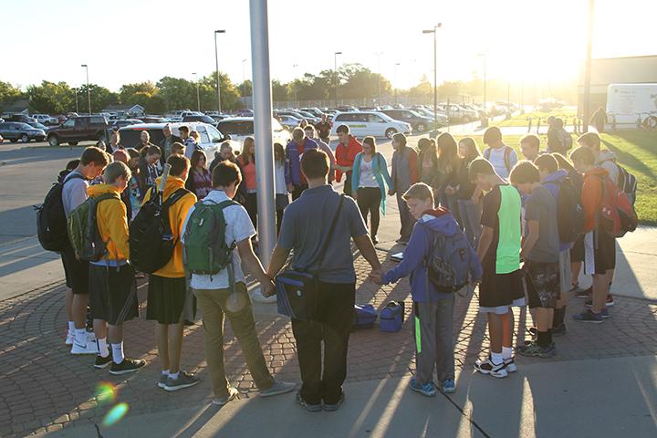 Students gather around the flag in prayer on Wednesday, September 28.