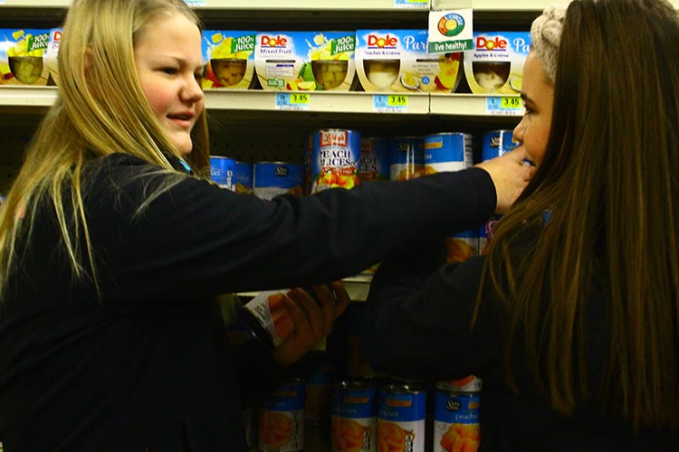 Freshman, Savanna States and Maggie Lashley deciding what items to buy at Garys Super Foods. 
