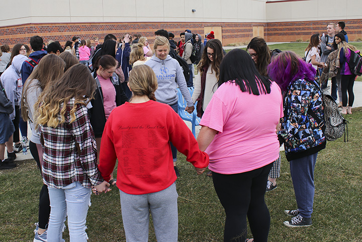 A group of students gather in a prayer circle during the walkout.
