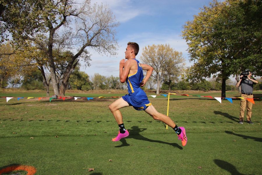 Evan+Caudy+runs+across+the+finish+line+at+the+GNAC+cross+country+meet+in+North+Platte+on+Oct.+11%2C+2019.