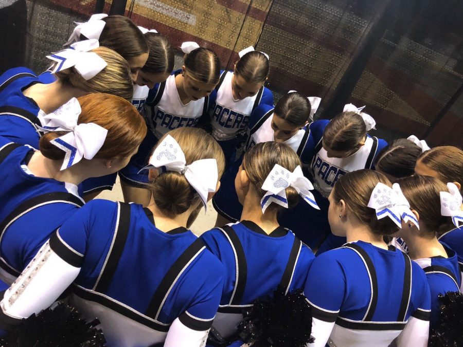 The Pacer dance team huddles to pray at state dance. Its a good luck thing, said sophomore Olivia Eckel. The pacers competed in jazz and pom. 