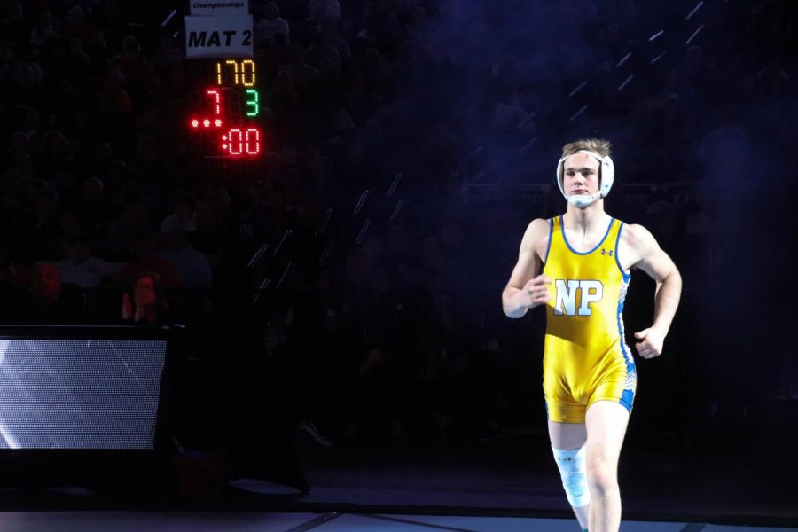 Junior Gavyn Brauer enters the arena on Feb. 22 at the CHI Health Center in Omaha for the championship match against Columbus Anthony DeAnda in the 182 weight class.  “It was nerve-wracking. Walking through the tunnel and the spotlights, I got nervous,” Brauer said.
