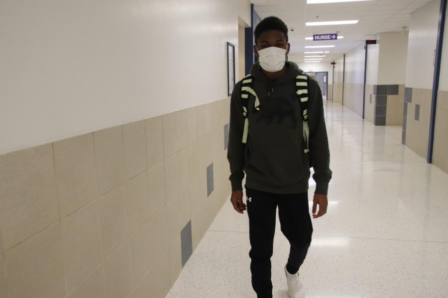 Junior Shemar Palmer demonstrates wearing a sick mask in school. Complete Family Health offers and recommends masks to people who have a bad cough. 