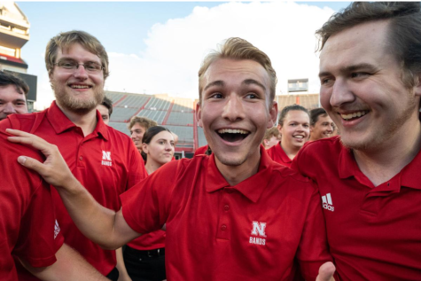 NPHS alum Drew Carlson (middle) celebrates after winning a competition during
the Cornhusker Marching Band Exhibition at Memorial Stadium on Aug. 19. Carlson
is one of six NPHS band students on the Cornhusker Marching Band. Fellow NPHS
alum, Lexi Nolda is seen behind Carlson. The Loper Marching Band has six alum.